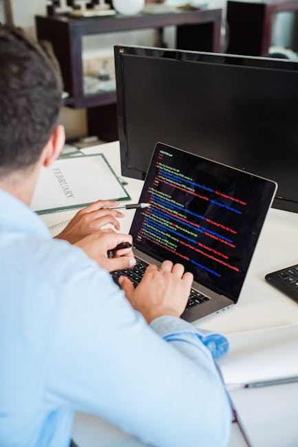 A close-up image of a computer screen displaying lines of HTML code in a text editor, with labels such as 'doctype html', 'html', 'head', and 'body' visible. The code includes meta tags, a title, and